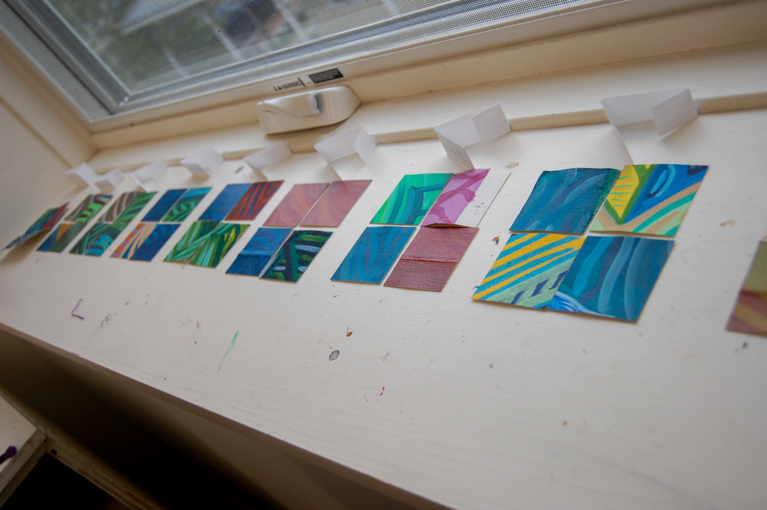 Translation Series paintings pre-planned and laid out on a window sill.