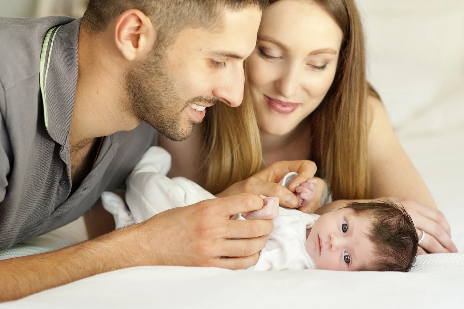 newborn baby on mum and dads bed perth baby photographer