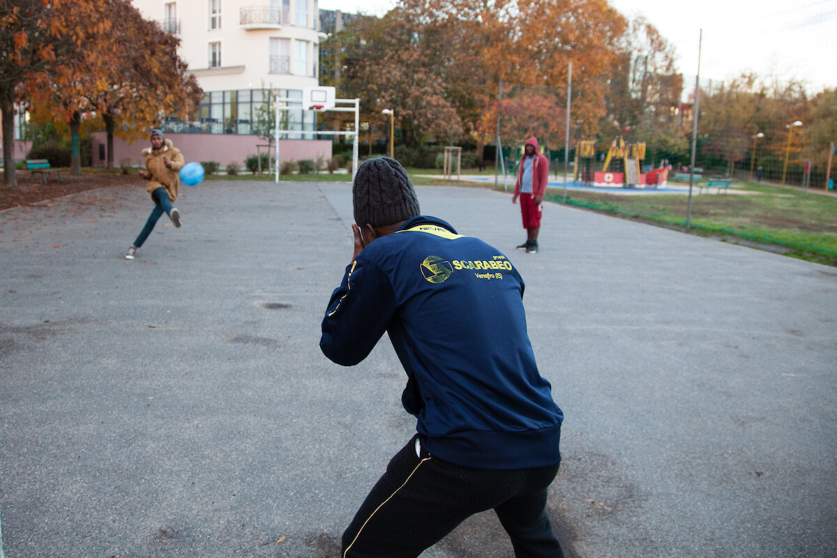  Des jeunes béneficiaires du programme Passerelle jouent  au football au stade du le parc proche de du centre d’hébergement, situé sur les rives de la Marne en région parisienne. 