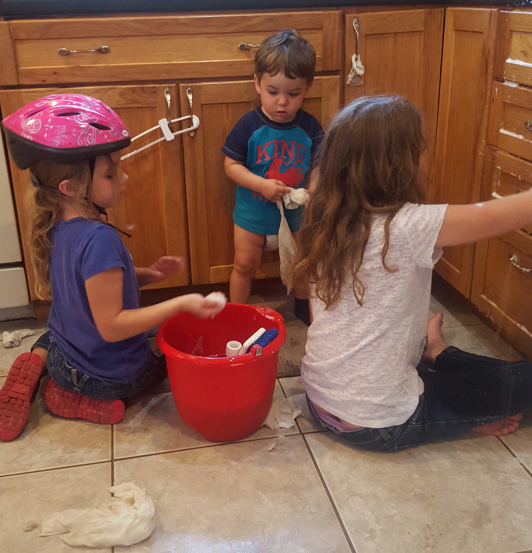 This is two of my girls (Kate, age 6 and Anna, age 9) and my son (17 months) scrubbing cabinets to earn money for charity. 