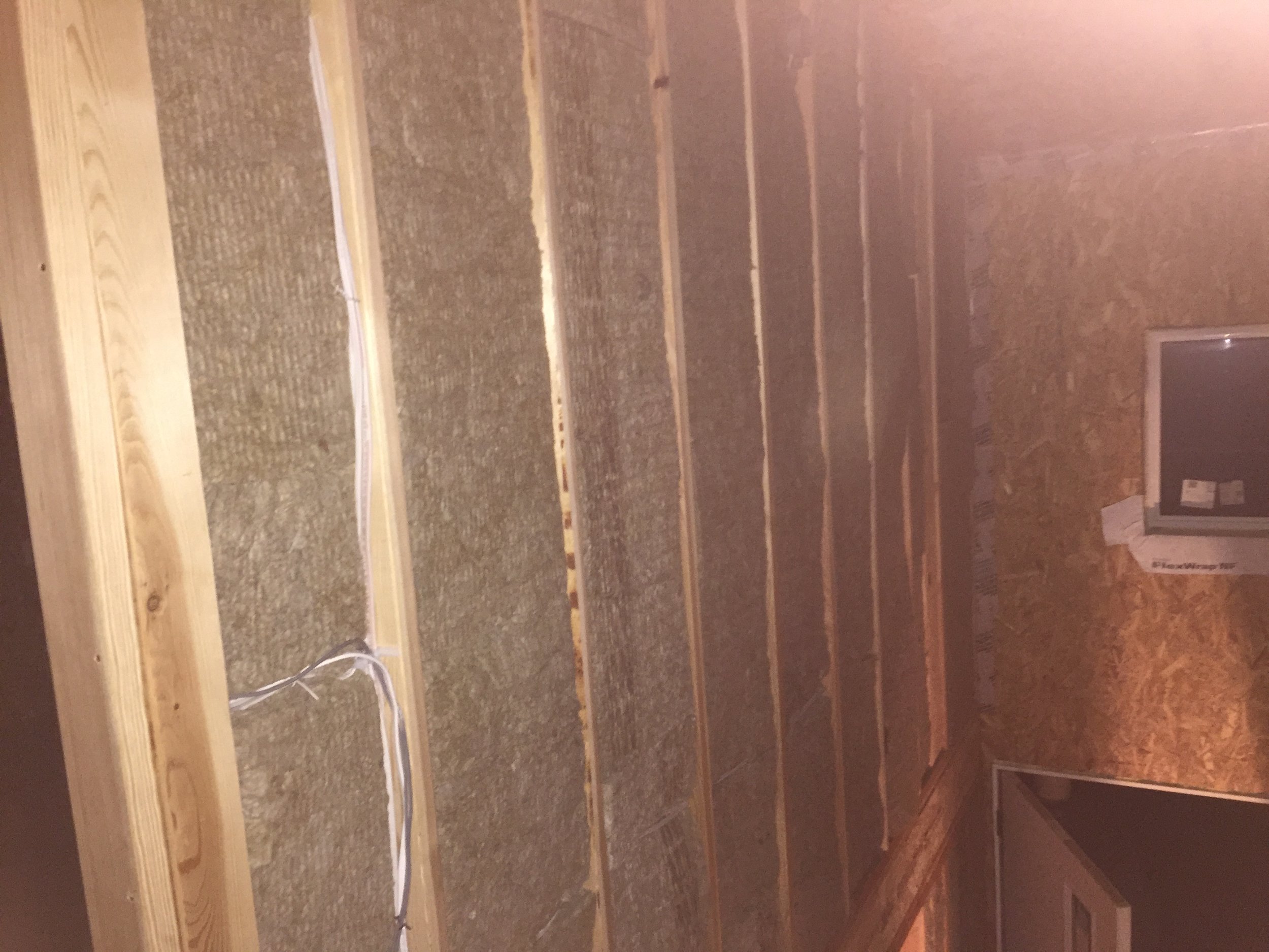 The gray material between the studs is Roxul Safe'N'Sound acoustic insulation, which also adds fire-proofing qualities to the wall.