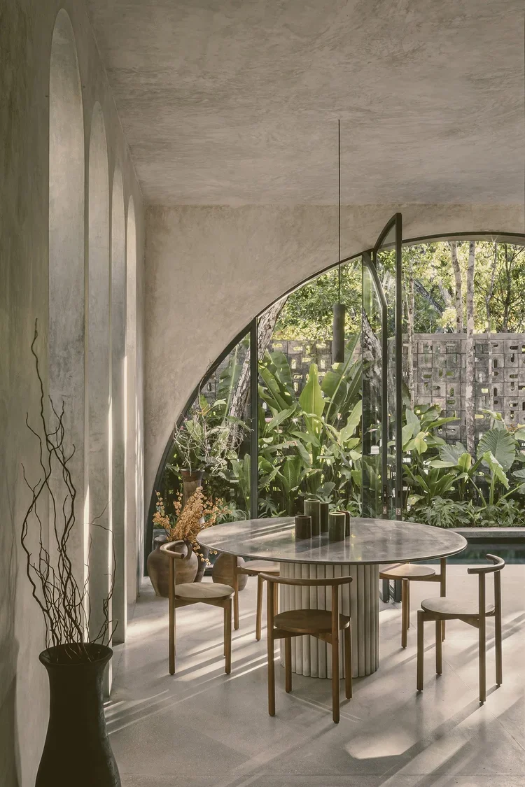 Villa Petricor Tulum — dining area, arched pivot opening to pool, bespoke marble table cast on-site, CO-LAB