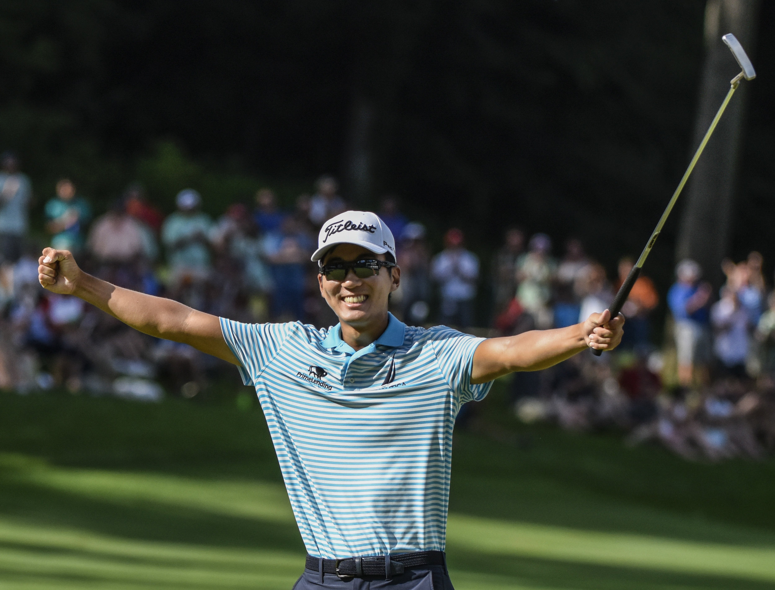  Michael Kim celebrates by throwing his hands into the air after his last putt on the 18th hole where he become the winner of the John Deere Classic golf tournament on Sunday, July 15, 2018, in Silvis. 