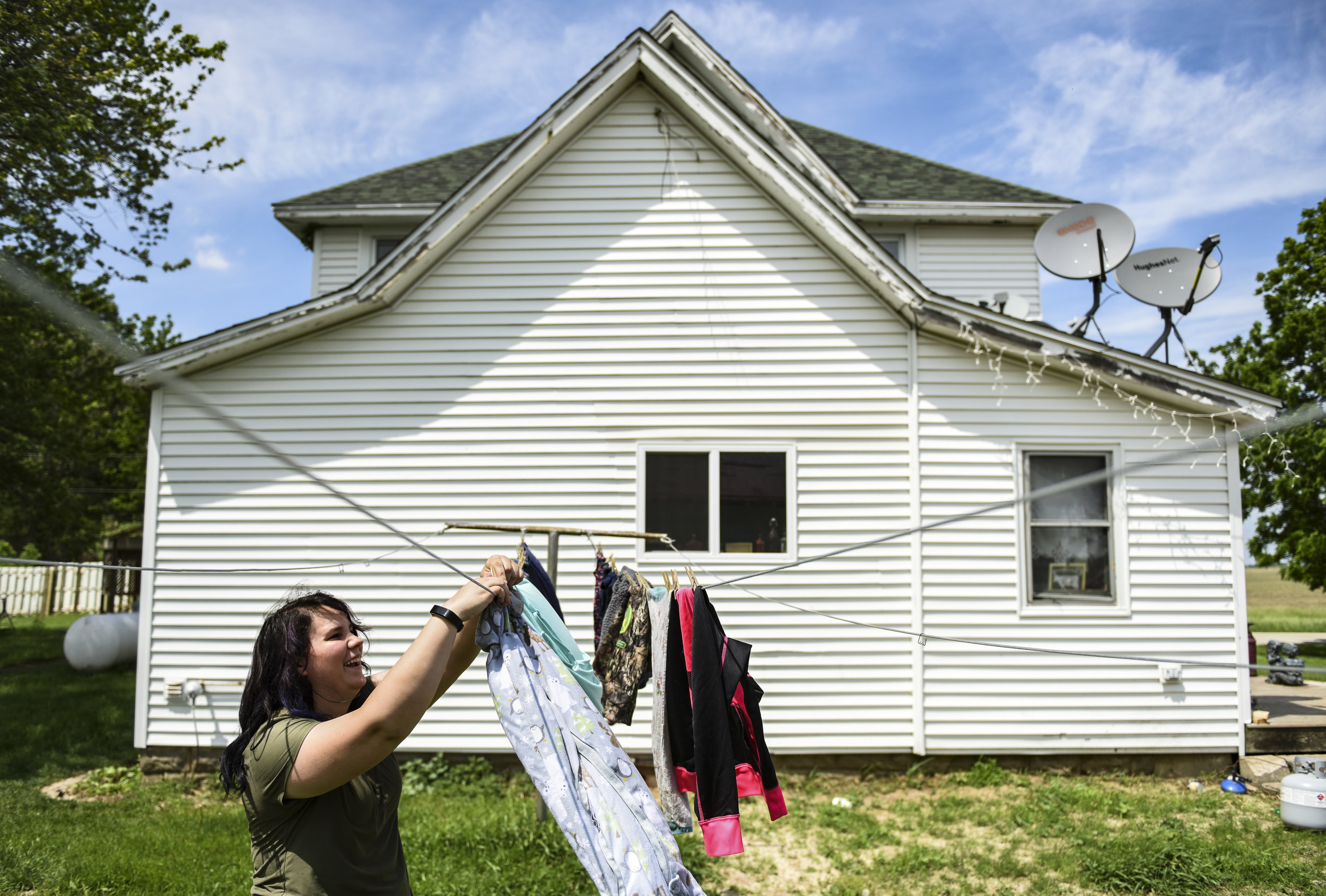  Julia DePauw hangs clean clothes on a clothesline before heading over to her in-laws' house to work on chores June 4 in Port Byron. 