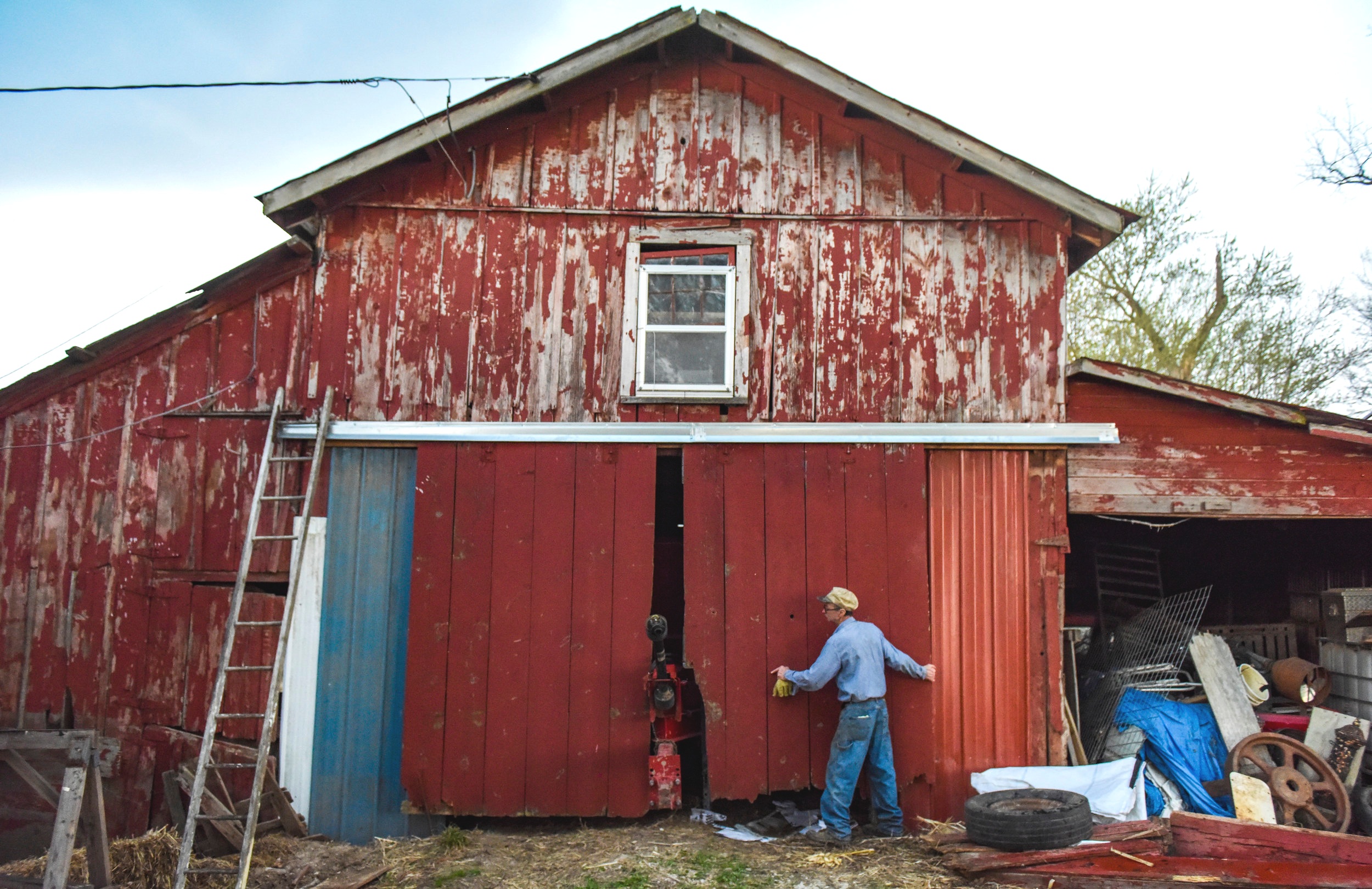  Bob DePauw closes the doors of one of his buildings before a rain storm at Trinity Acres April 22 in Port Byron. 