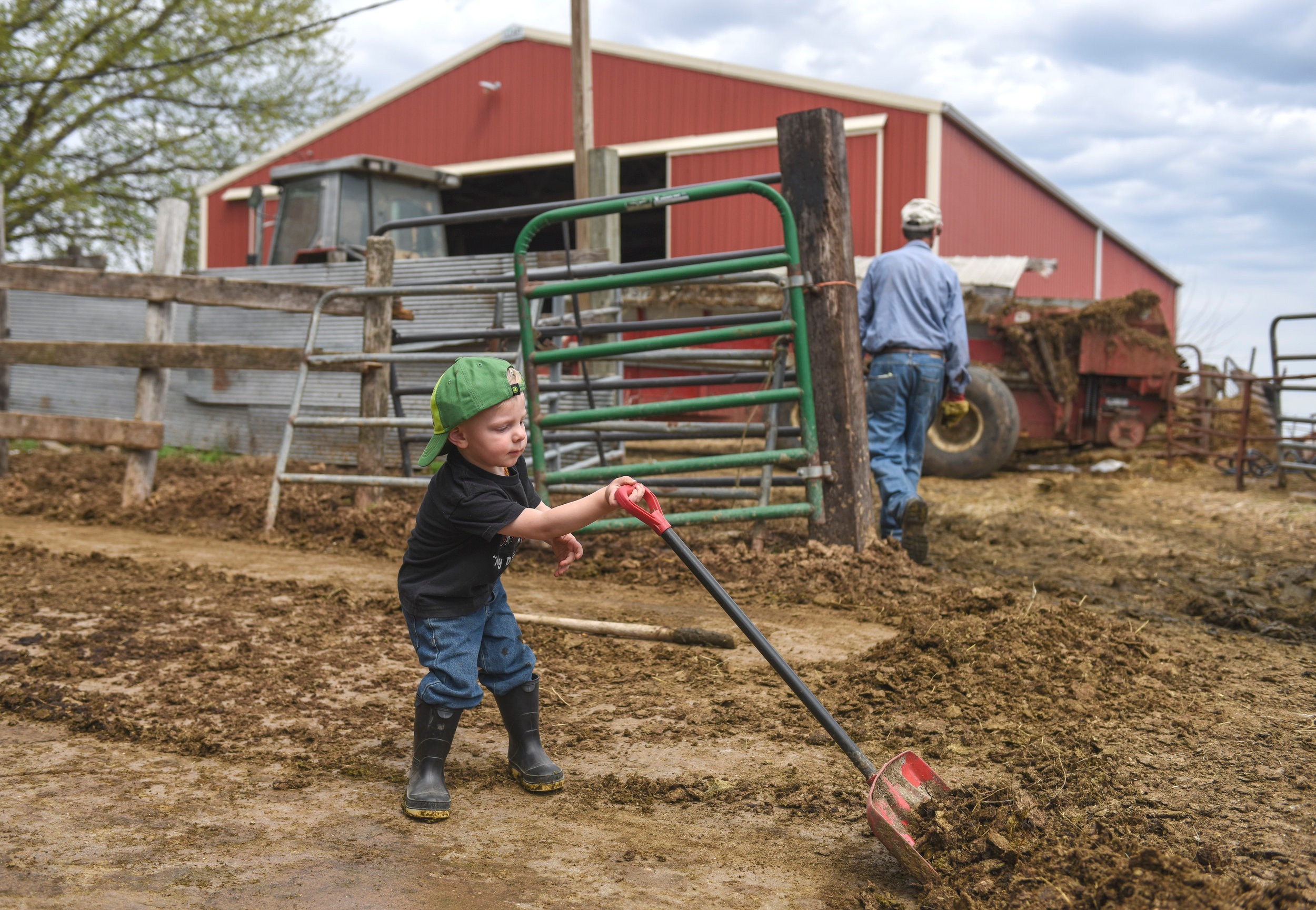  Theo DePauw clears cow manure in the entrance of the milking parlor of Trinity Acres Monday, April 22, at Port Byron. Theo, 2, handles some responsibilities at the farm, doing chores like this one.  