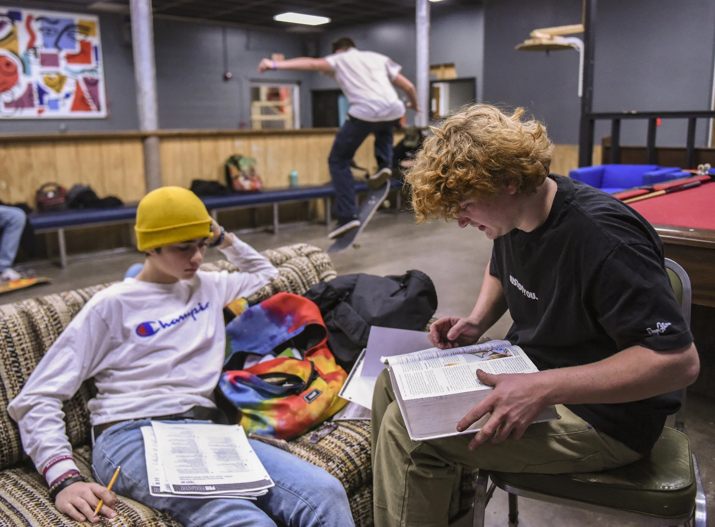 Brady Hovery, 14, of Davenport, receives help with his homework from Johnny Garrett 17, of Davenport, before they begin skating at The Center Dec. 11 in Davenport.