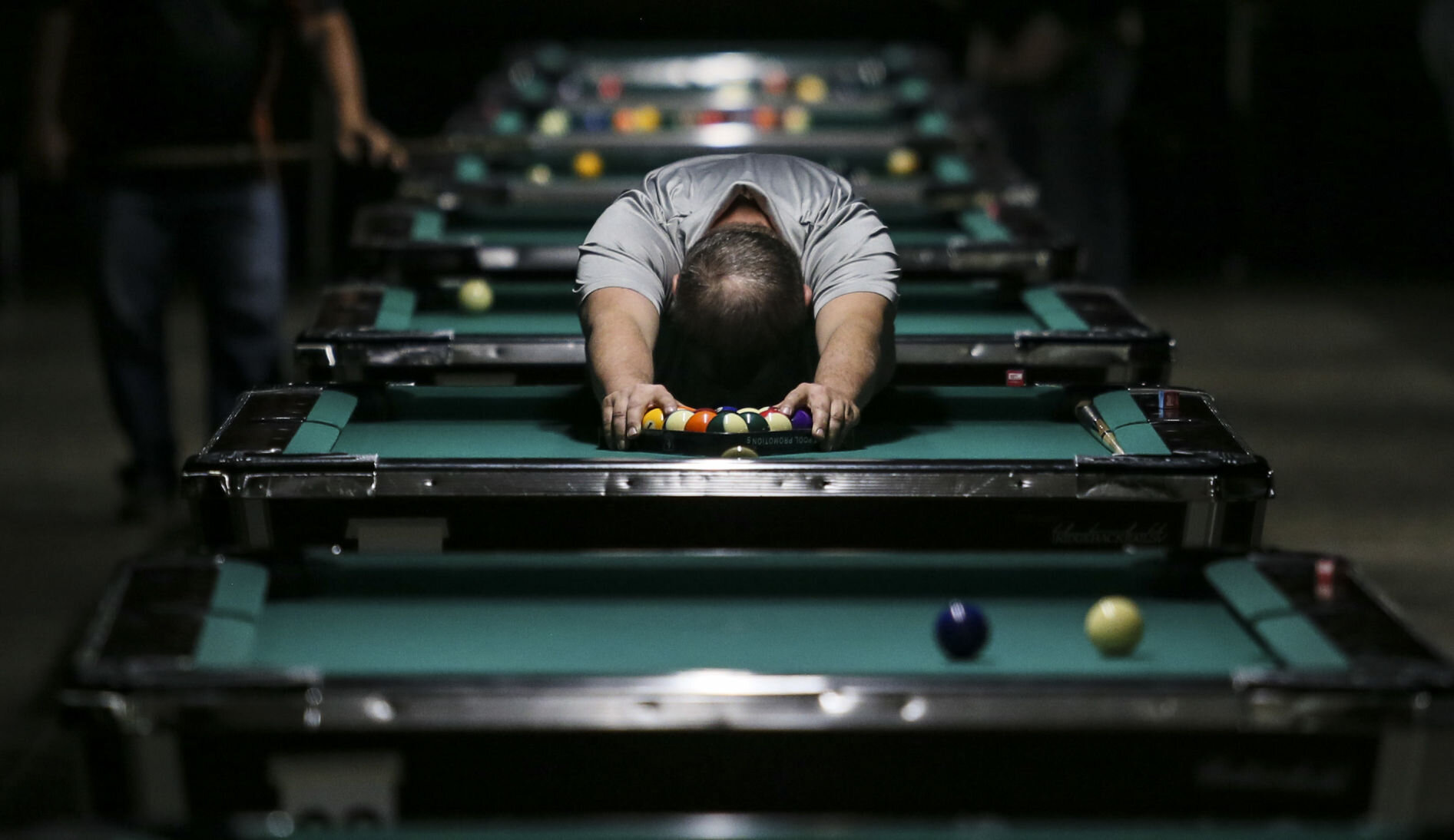  Rob Knudsen of Princeton stretches his shoulders while racking the balls during 2019 Iowa ACS Iowa State Pool Championships at the RiverCenter in Davenport. 