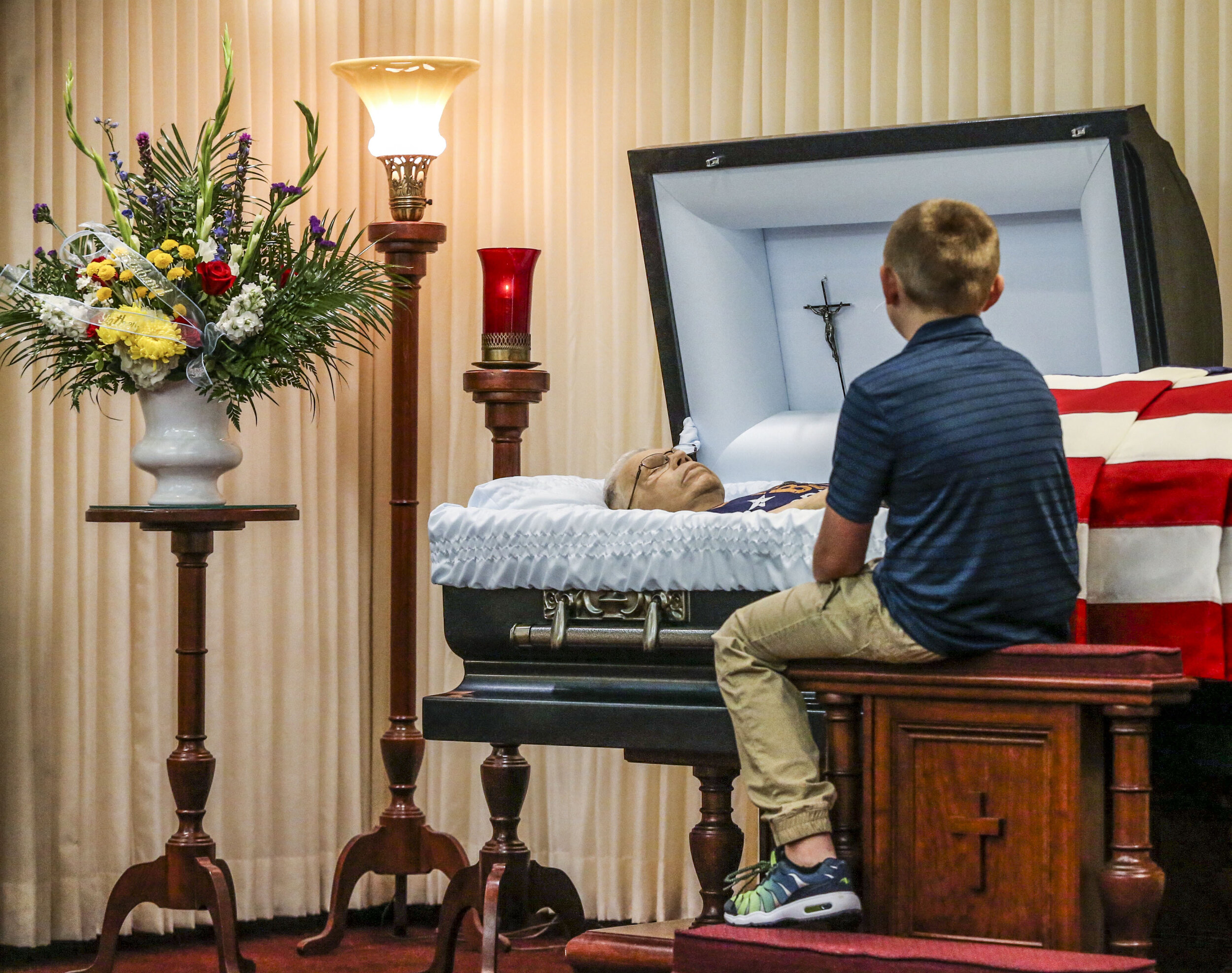  Andrew Gustafson, 8, of Cambridge sits beside his late grandfather, Joseph B. Burns's casket before a television live stream during a drive-thru only visitation for his service Sunday, June 14, 2020 at Wheelan-Pressly Funeral Home and Crematory in R