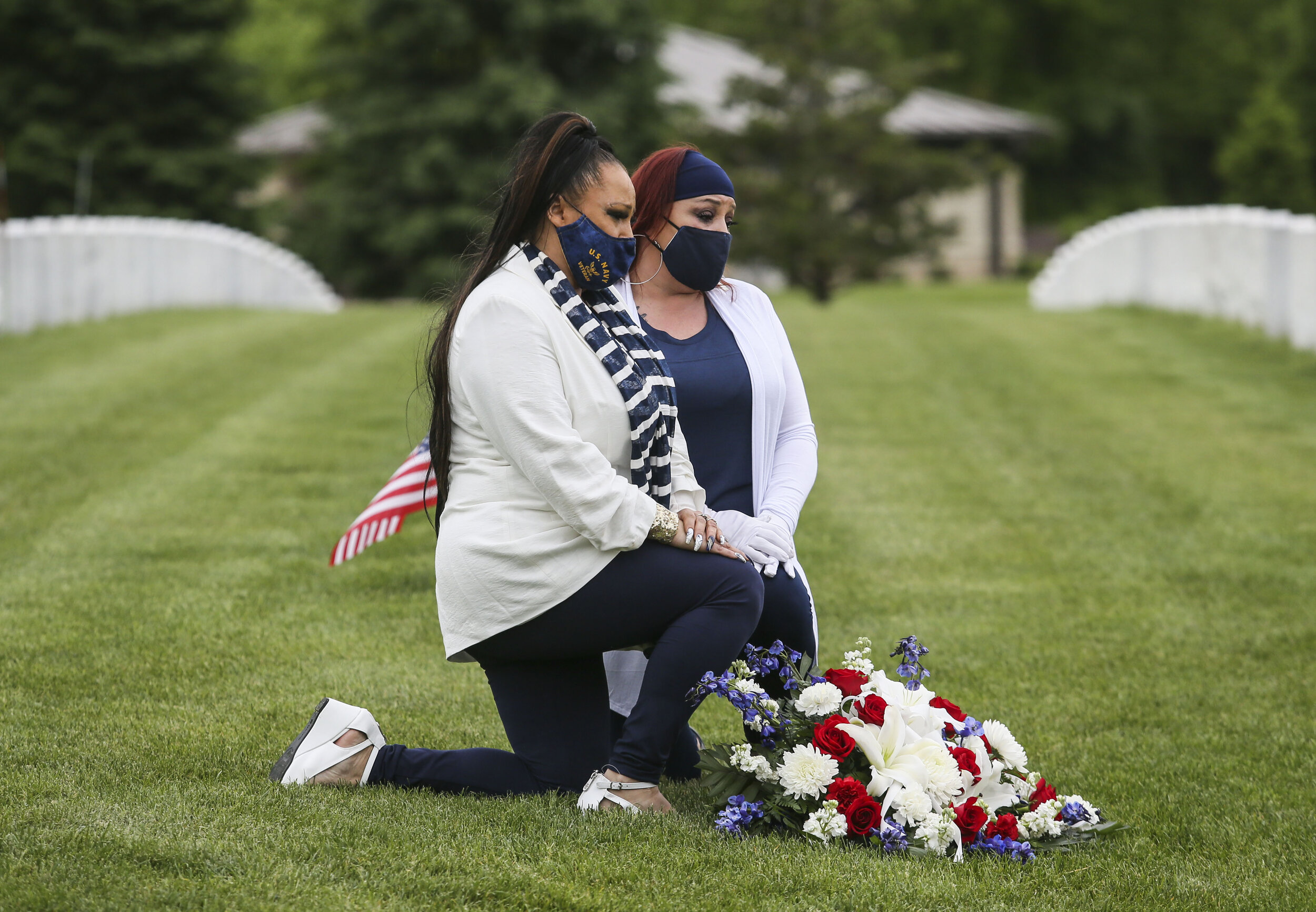  Crystal Antu and her sister Shantell Antu-Beechum sit with flowers that will be laid with their late father's grave at the Rock Island National Cemetery, May 21, 2020. The family was not allowed near the gave site while the casket was being lowered 