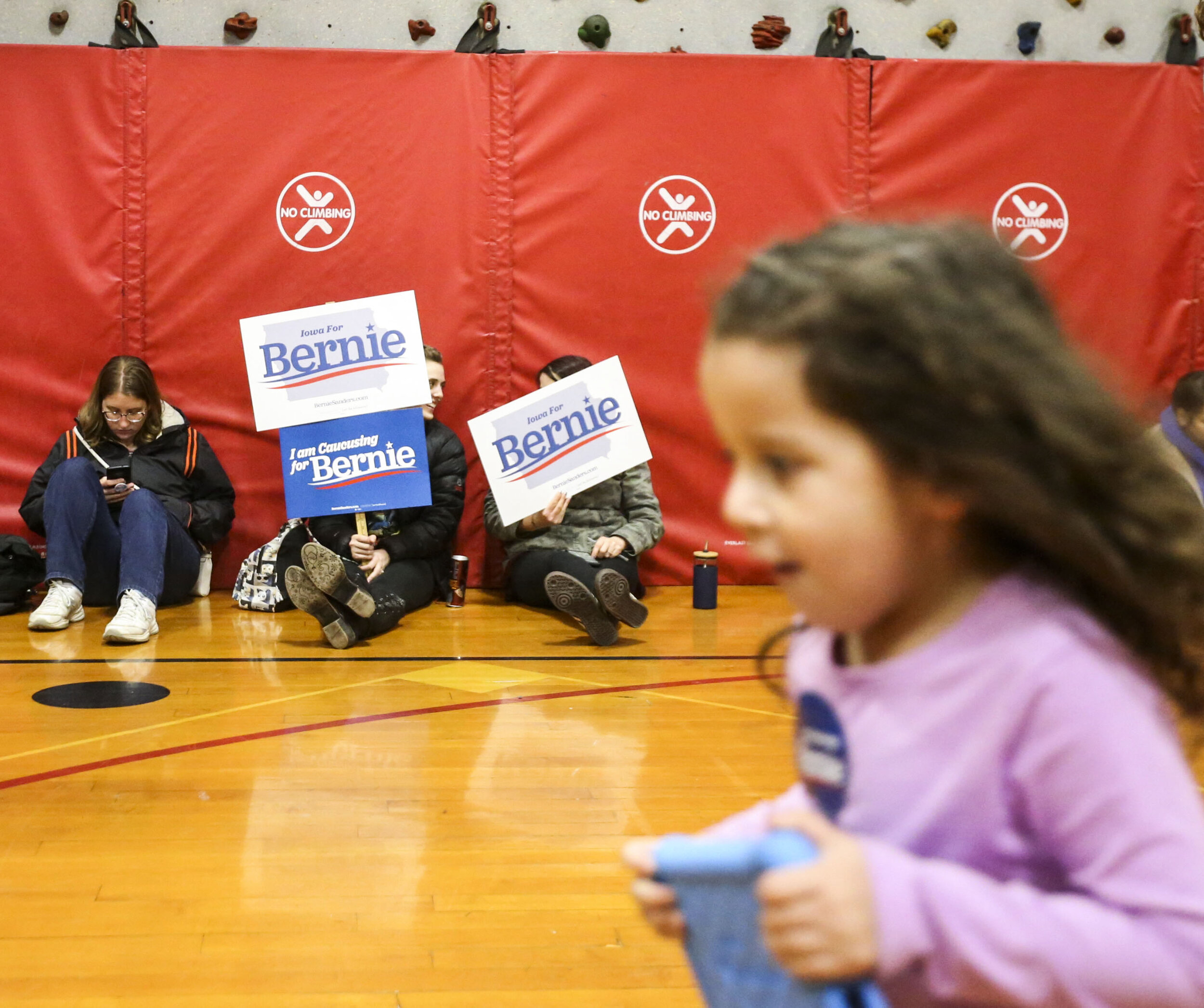  A child runs while Bernie Sanders supporters wait to be counted during the Iowa Caucus at Washington Elementary School Monday, Feb. 3, 2020. 