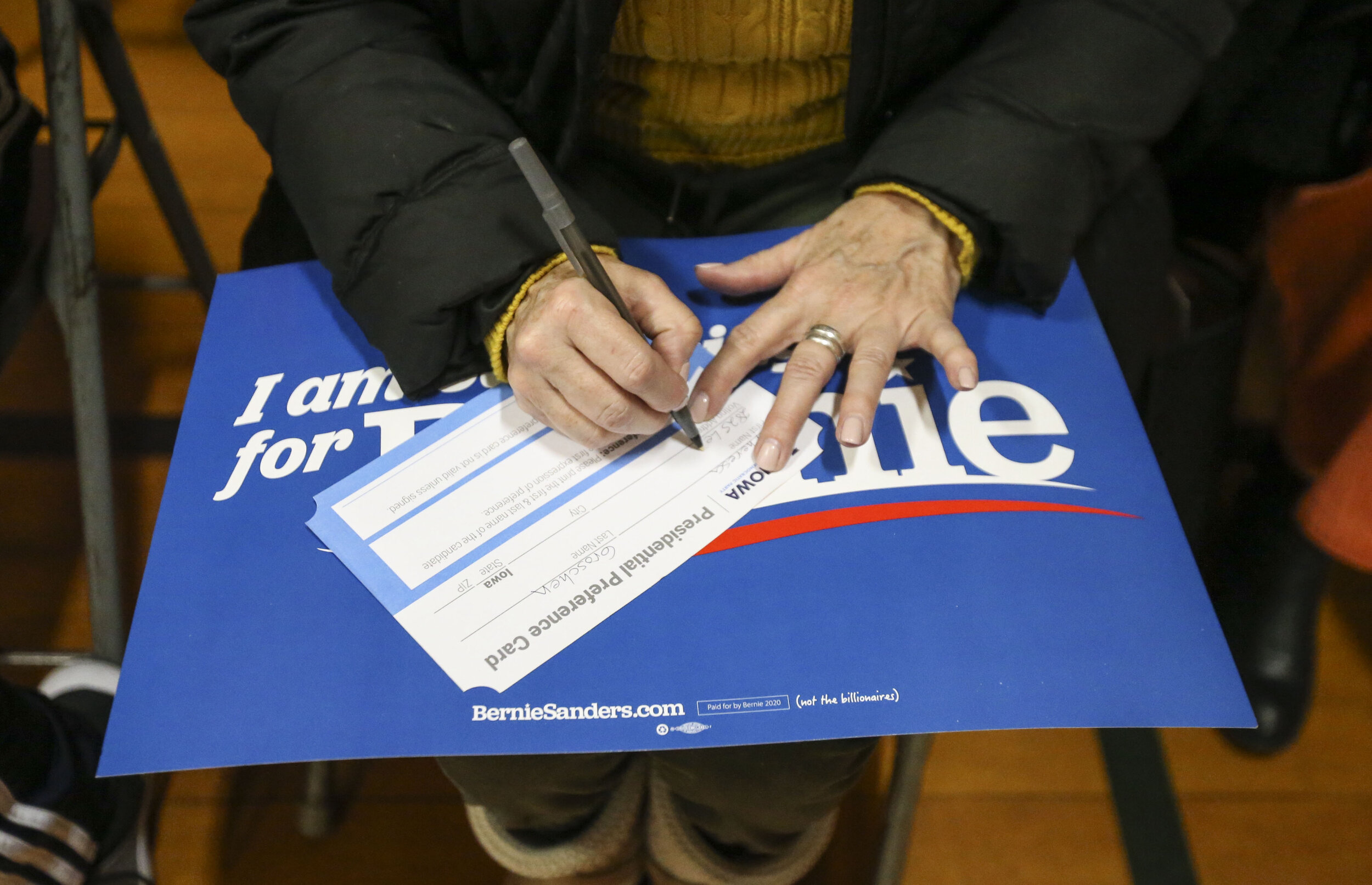  An Iowa voter writes her petition cards in support of Presidential candidate Bernie Sanders during the Iowa Caucus at Washington Elementary School Monday, Feb. 3, 2020. 