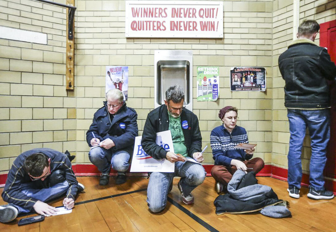  Three men center left to right, Neal Smith, Ron Johnson, and Chris Houser fill out their petition cards for Sen. Bernie Sanders during the Iowa Caucus at Washington Elementary School Monday, Feb. 3, 2020. 