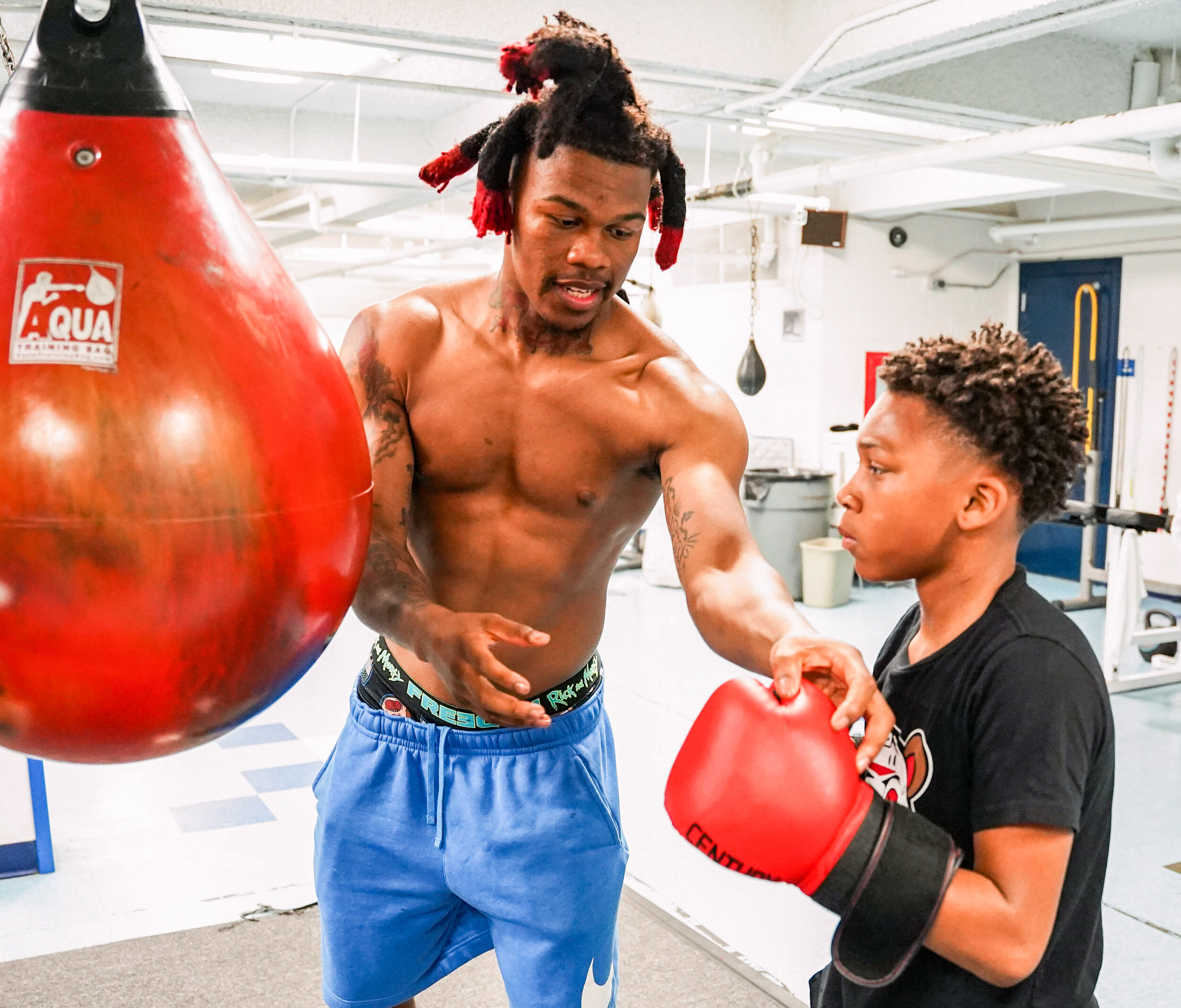  Pachino Hill shows Quincy Ross proper techniques at Pena's Boxing Club in Davenport, Monday, May 3, 2021. 