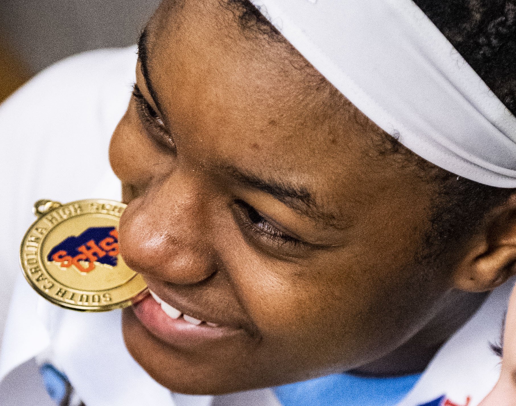  Christ Church's Yasmene Clark (21) bites down on her medal after defeating Andrew Jackson in the Class AA in the SCHSL state championship game at the USC Aiken Convocation Center Saturday, March 5, 2022. 