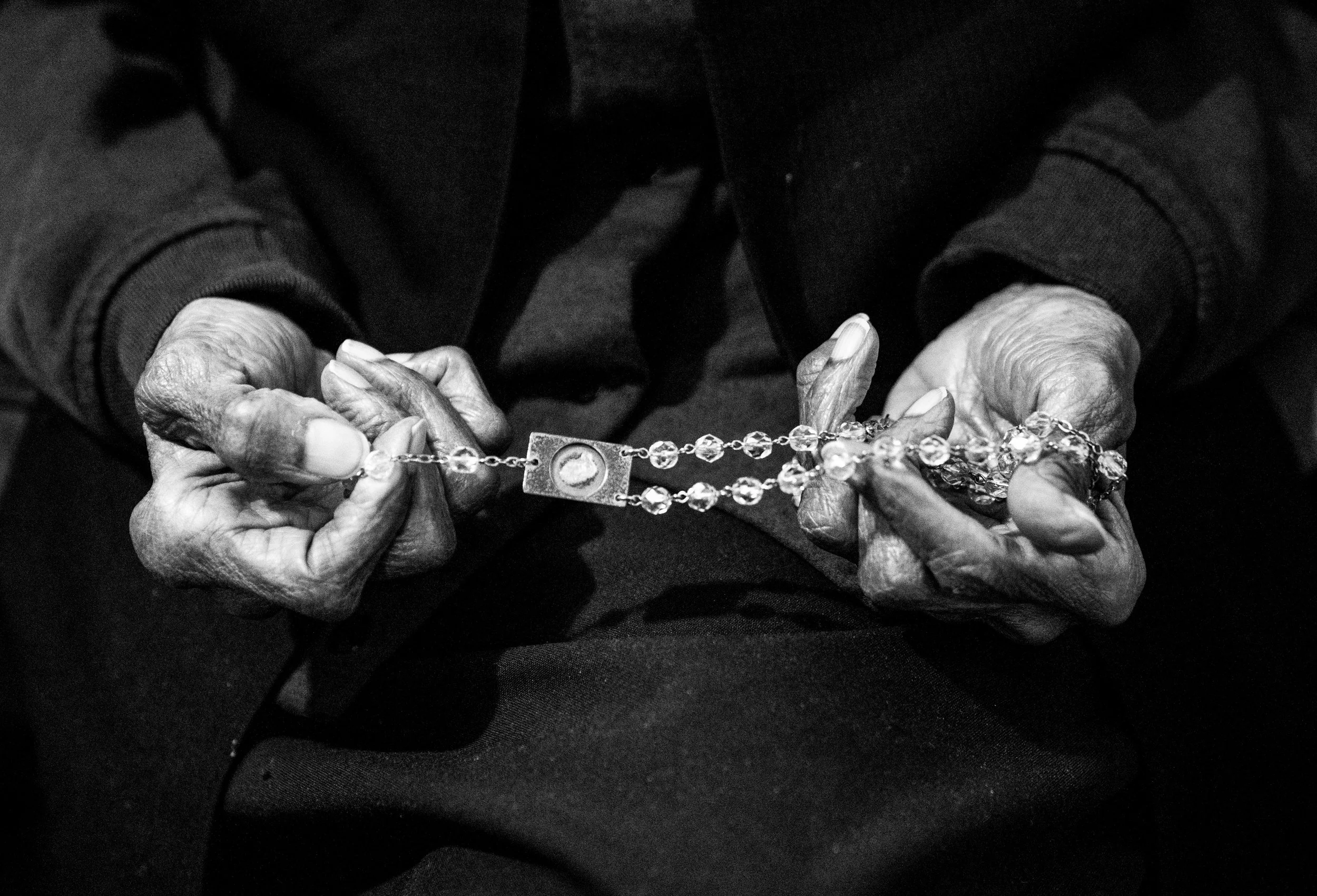  Sister Magdala Gilbert prays holding her rosary during Mass. 