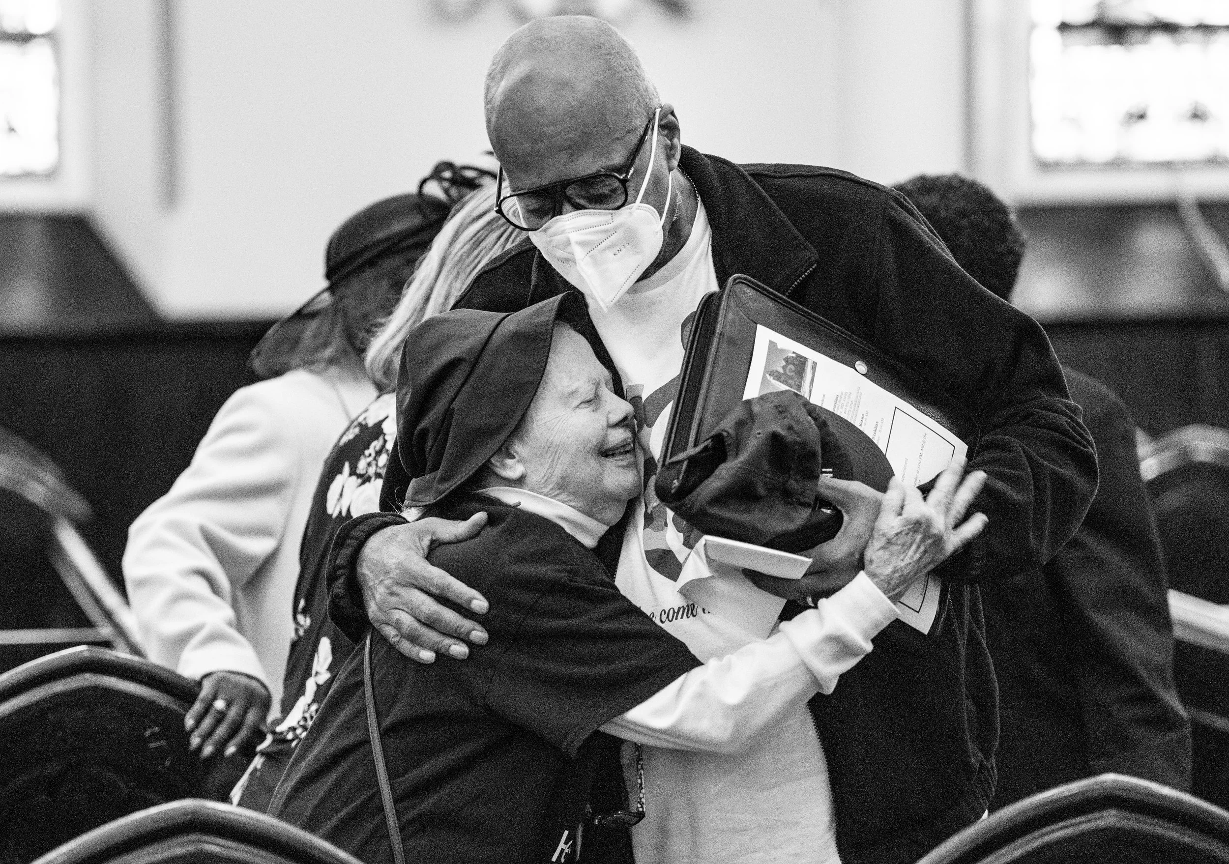  Ralph Moore gets a hug from Betty Lutz after a church service at St. Ann’s before Moore grab suitcases to grab to catch a flight to Rome. 