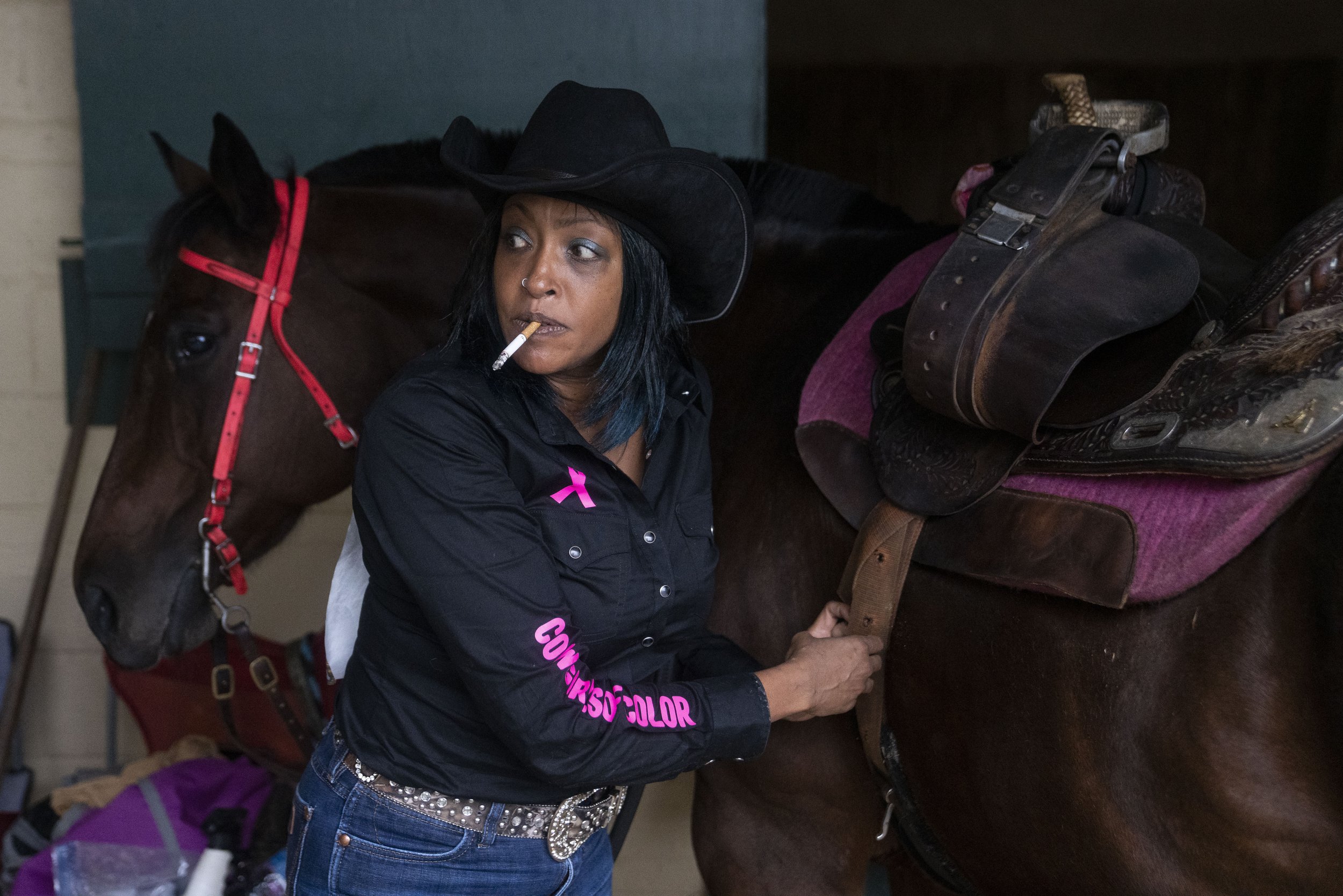  Leslie DeLacy prepares her horse before competing in the Bill Pickett Invitational Rodeo, at the Show Place Arena. 