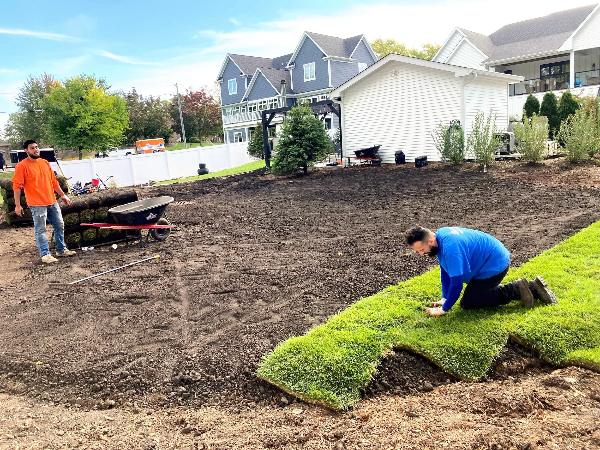 Landscaping crew installing fresh sod for a new residential lawn