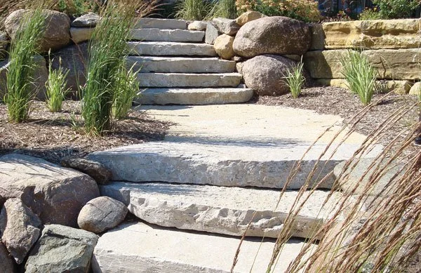 Natural limestone steps and outcropping stone installed in a residential landscape