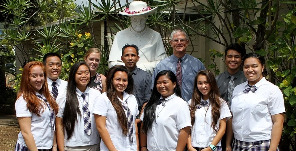 Mr. Carrasco (standing in front of the statue of St. Damien), Principal Br. Daniel Casey, teacher Elle Stricklen, and some of the students who were slated to attend the Mission Trip to Kalaupapa in 2015.