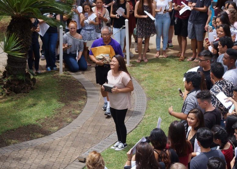 Senior class president Kim Aguada beams as she readies to place the 2016 class paver in the pathway. 