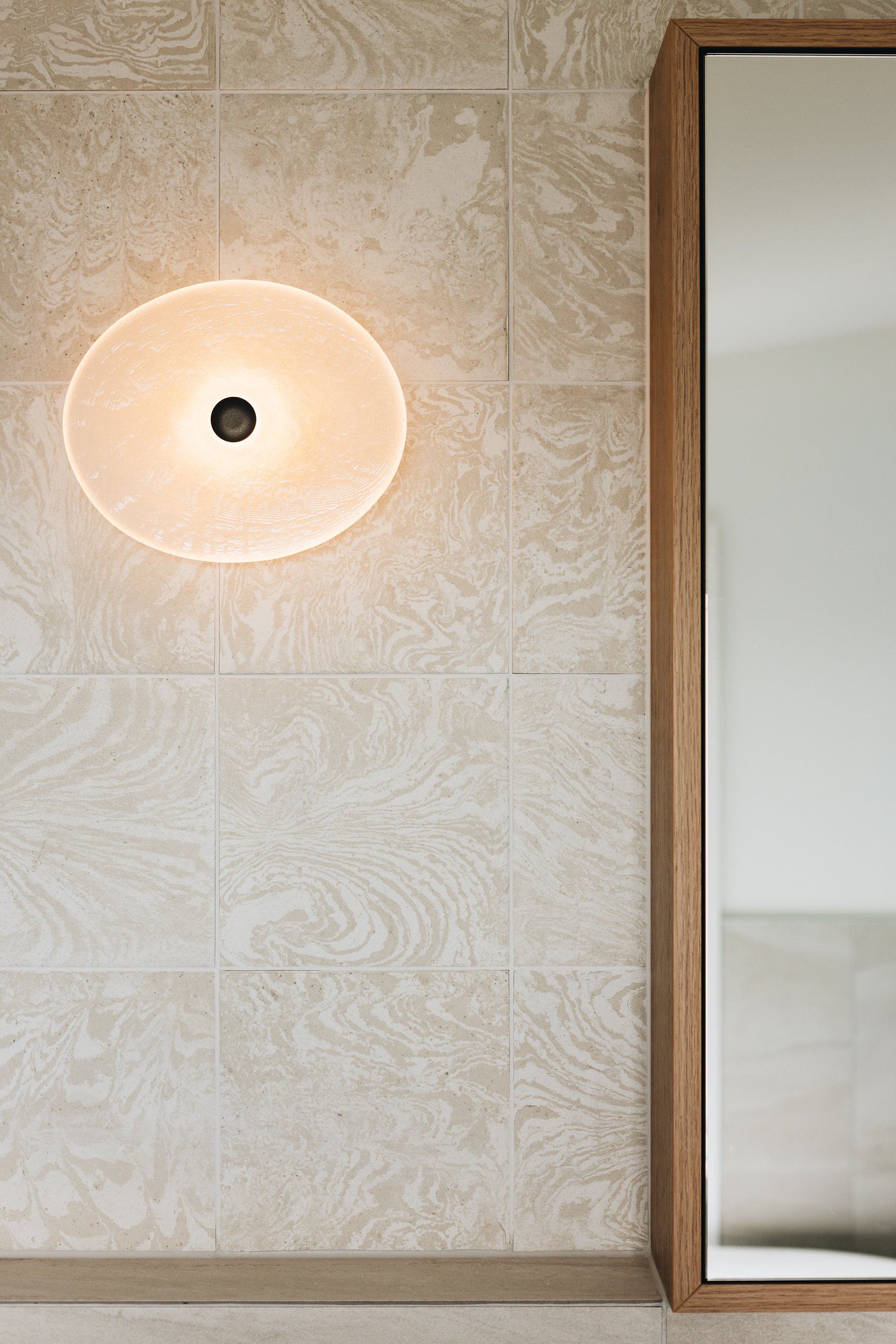  Elegant ensuite with Soktas wall light and custom mirror cabinet 