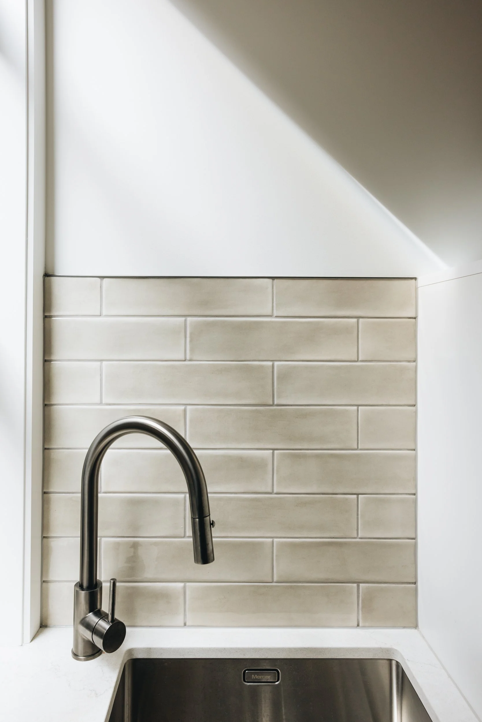 sleek-dark-tapware-taupe-tile-kitchen.jpg