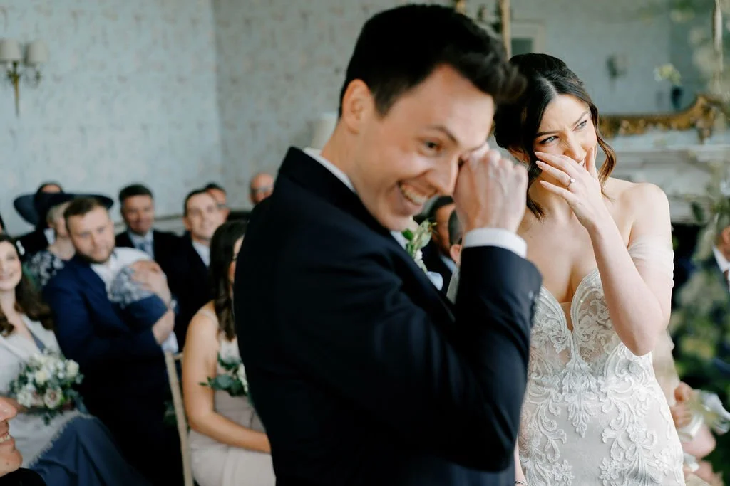 Bride and groom at the alter, both crying with the emotion of their wedding ceremony