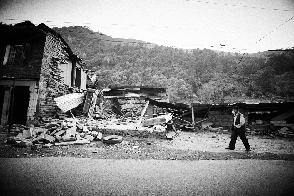 A man walks past the destruction. A lot of people were wearing masks due to the massive amount of dust caused by the landslides.