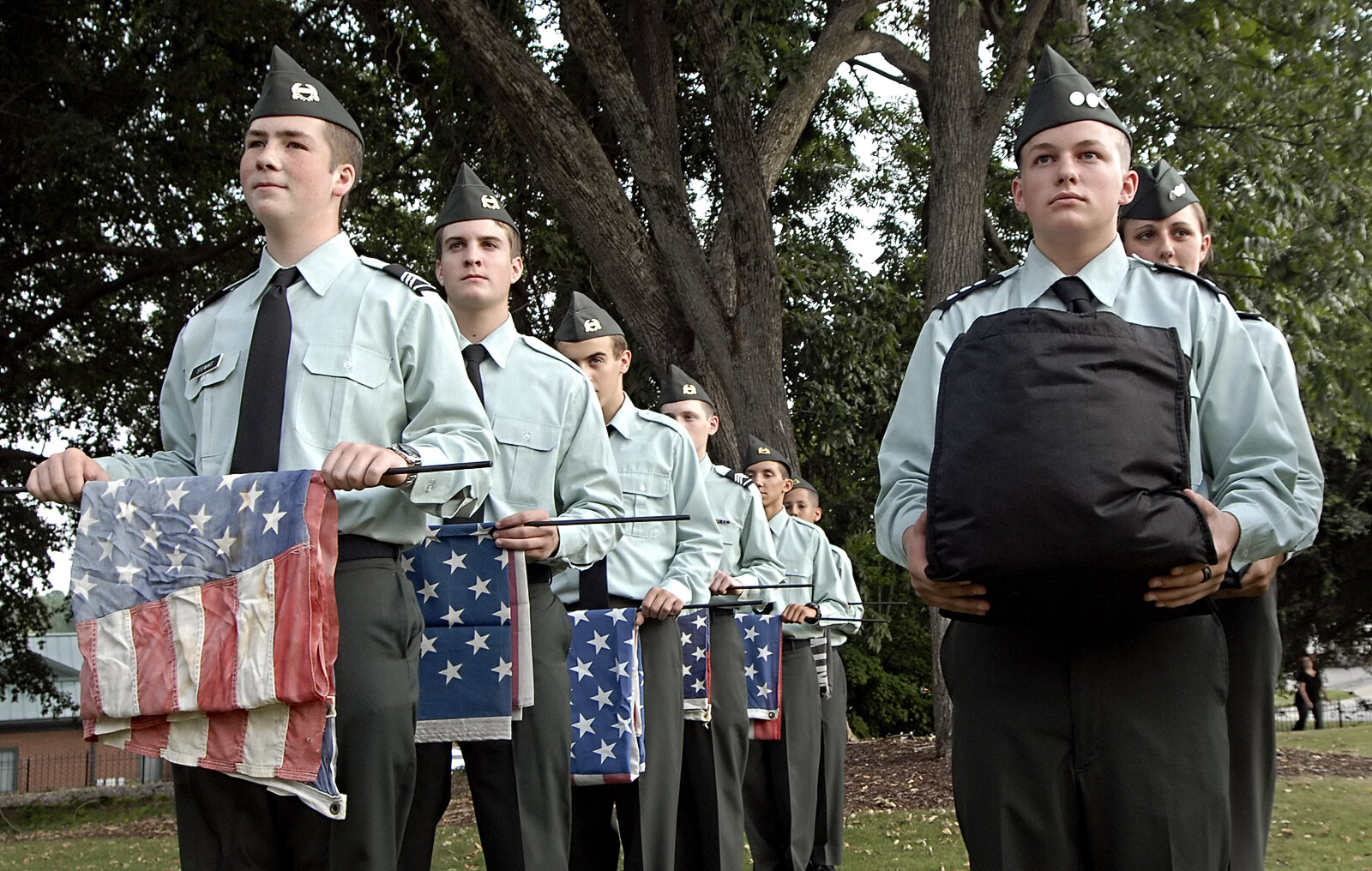  Sophomore Ivan Stewart, 15, son of John and Valerie Stewart of Marietta, left, holds one of five flags that will be retired during Friday’s ceremony as senior Eric Hargis, 16, son of Shelly and Russ Hargis, right, holds a bag filled with flags that 