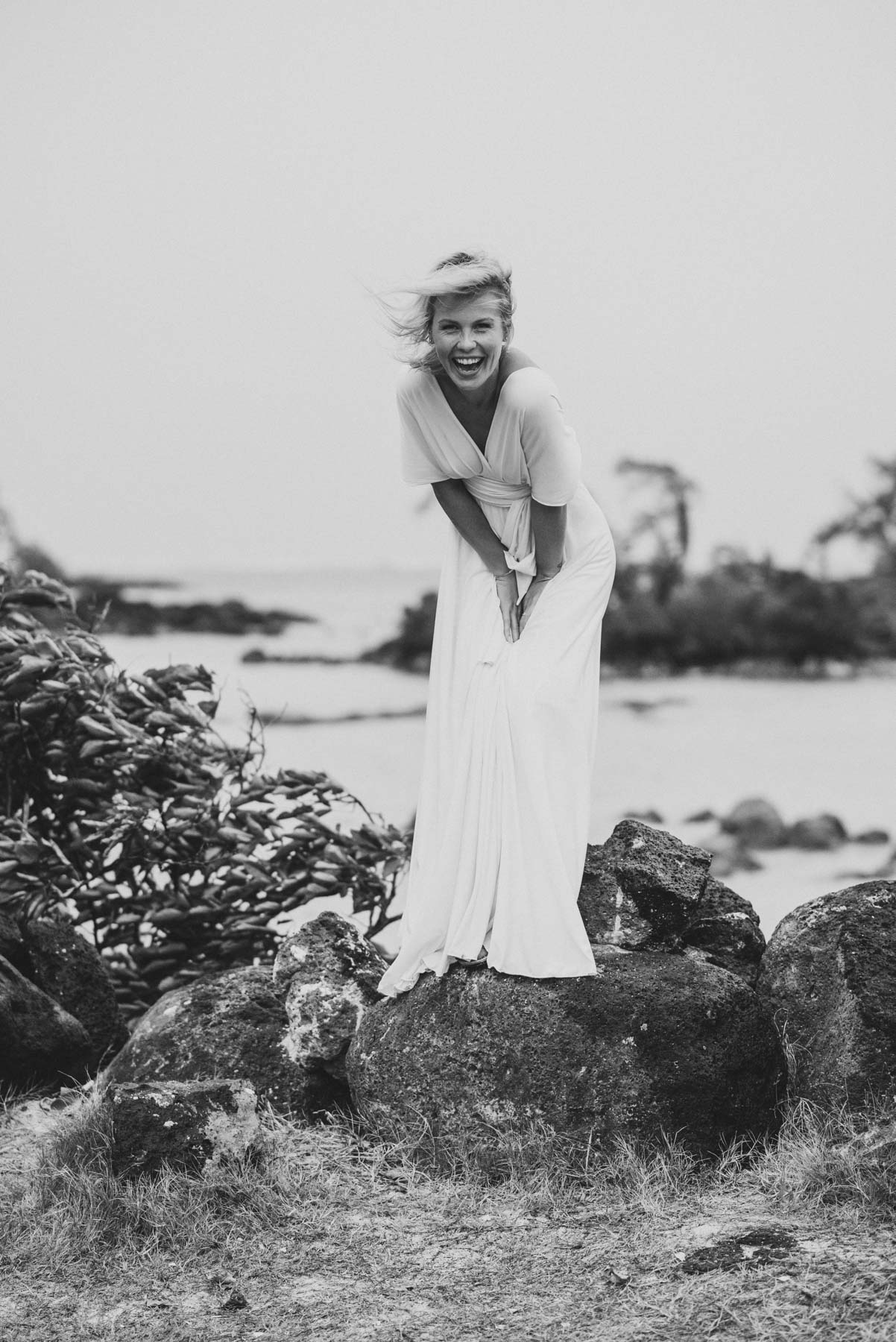 Copy of Sita Kelly | Mauritius Honeymoon Photographer | woman in white dress standing on a rock and laughing