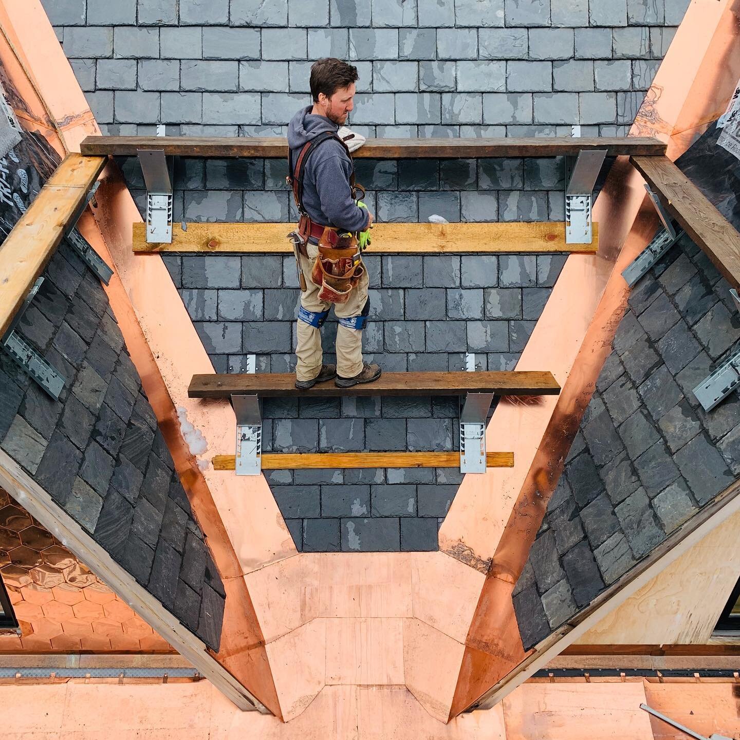 Our #masterbuilder surveys his work between the dormers. We are loving the way the #blockcopper looks in this valley. #vermont #slate and #copper #roof. 
#artisancrafted #builttolast #roof #carpentry #timberframe #postandbeam #construction #supportlo