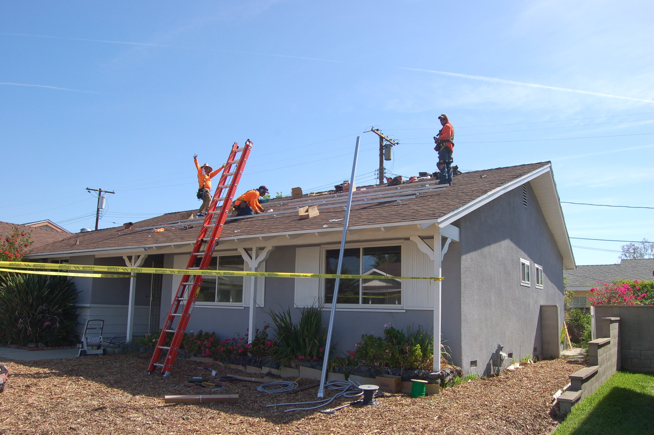 A local solar company putting supports for PV panels on our roof. No that's not a tiny man on the ladder.