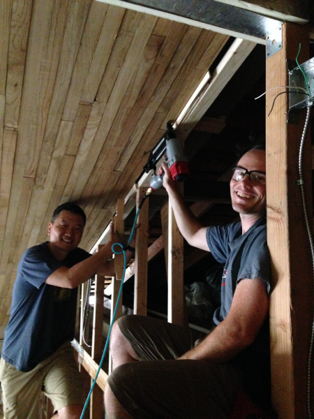 Sang and Chris install the final piece of paneling.