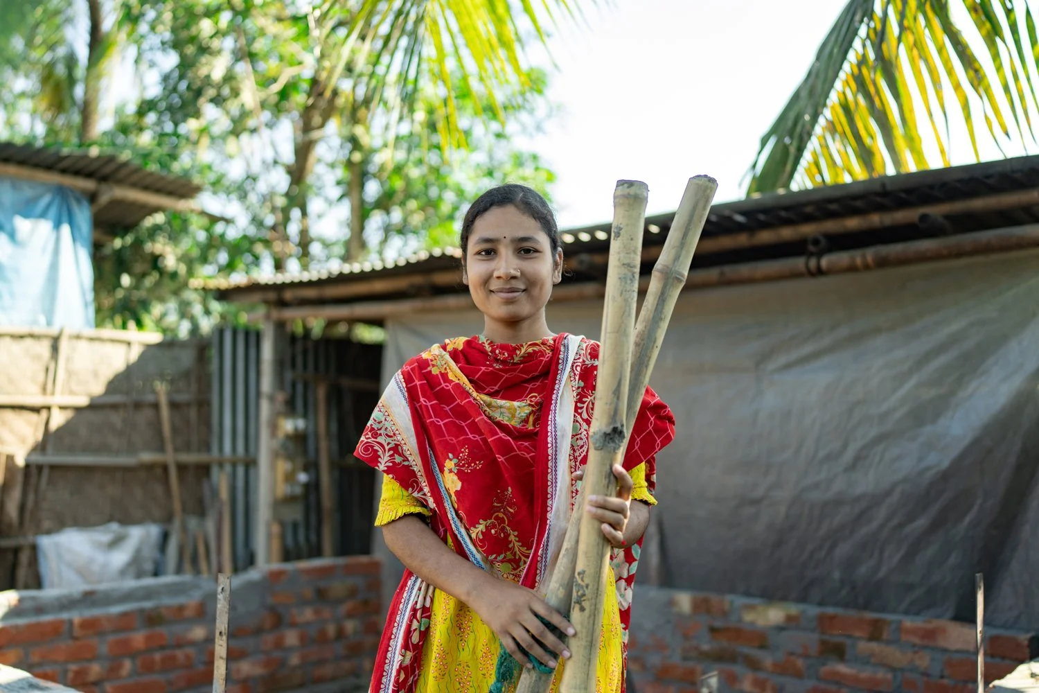 Woman holding bamboo, ready to build