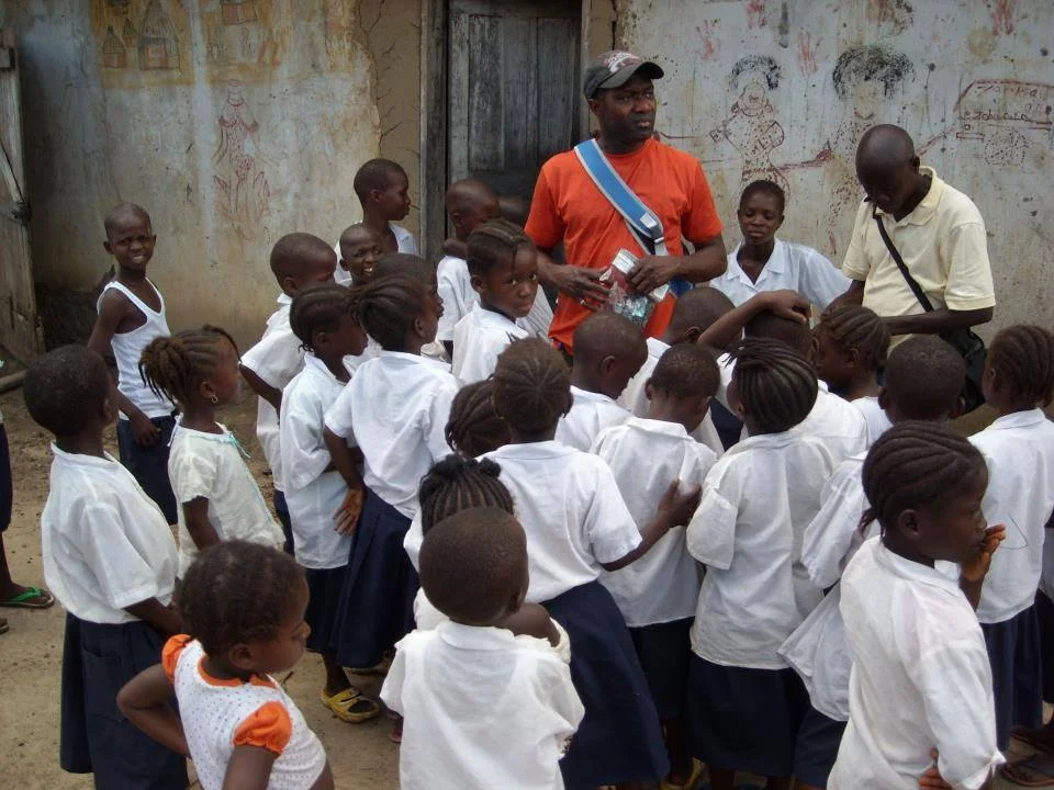 Jesse Matthews and the kids having fun at the school during his visit to Galai, Bong County in 2012.
