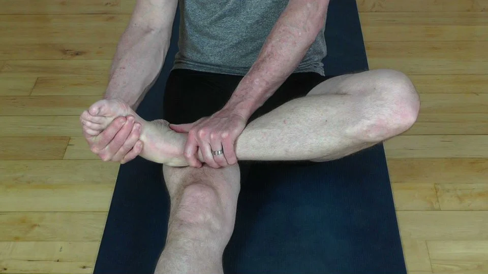 Ankle stretch using one hand as a fulcrum.