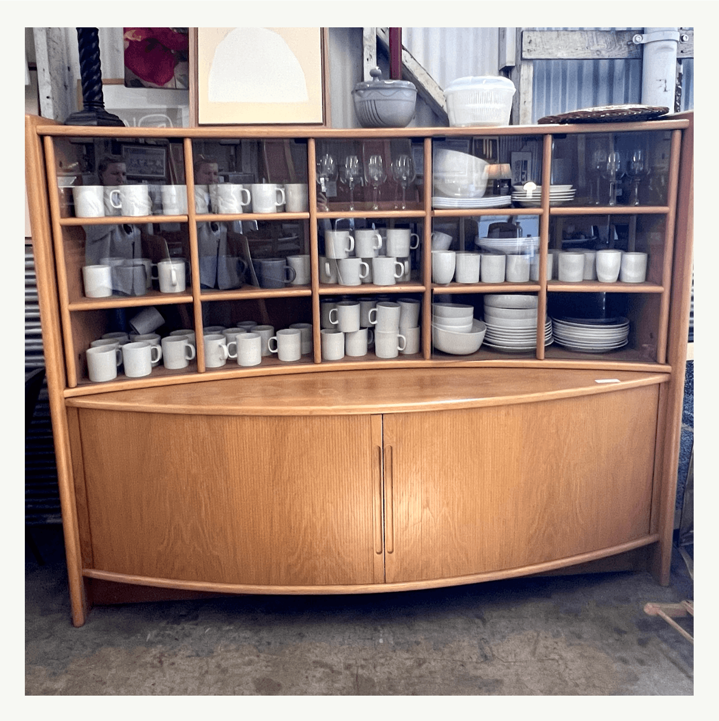 Mid-century modern teak china cabinet with curved oval base and tambour doors at Poor Honey's Oakland — a Bay Area furniture restoration find