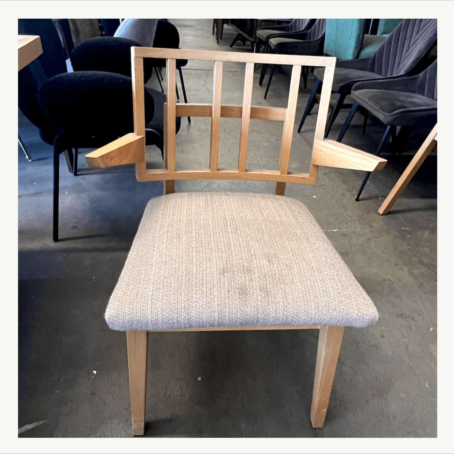 Mid-century dining chairs with geometric grid backrests and worn neutral seats at Poor Honey's Oakland — ready for reupholstery and refinishing by Revitaliste in the San Francisco Bay Area