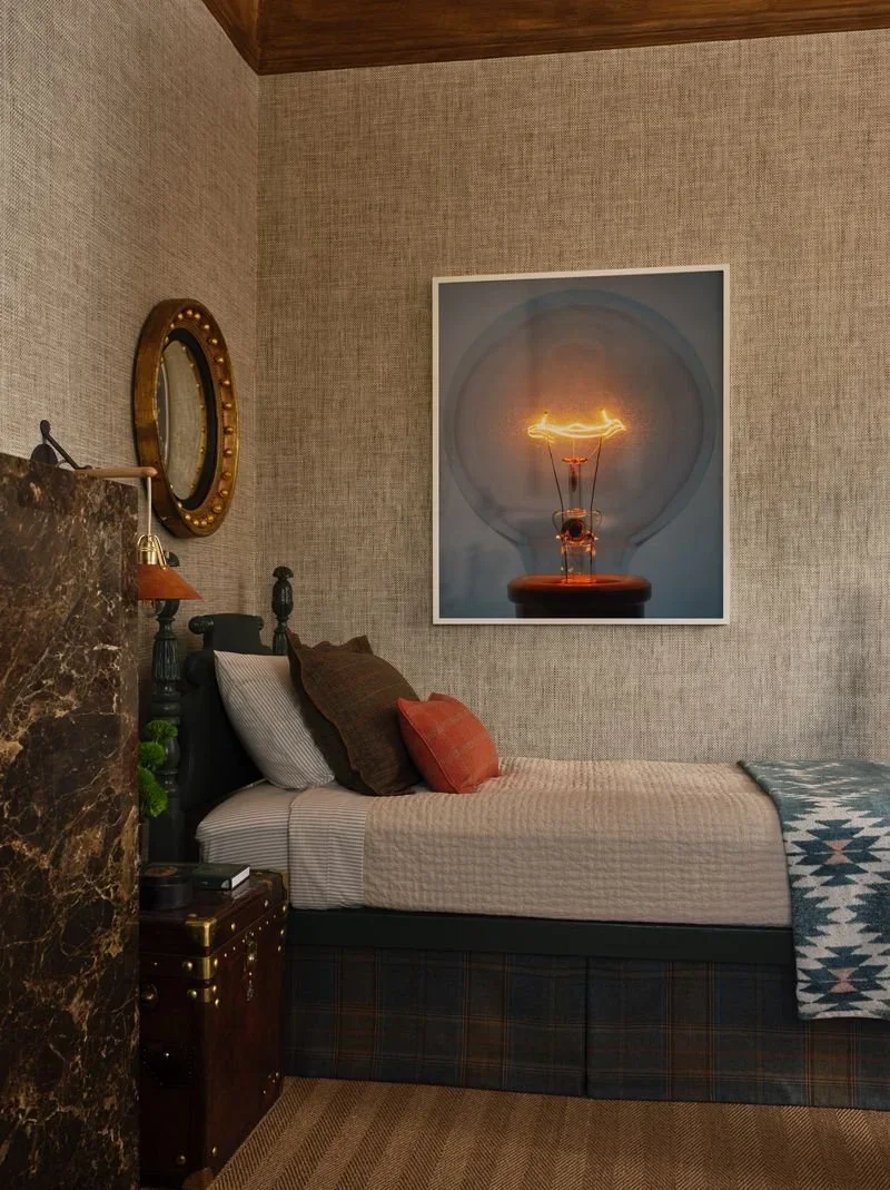Twin bed lacquered in custom green by Revitaliste with oversized lightbulb photograph and dark marble fireplace in Jeffrey Neve Interior Design's Double Standard bedroom at the 2026 San Francisco Decorator Showcase