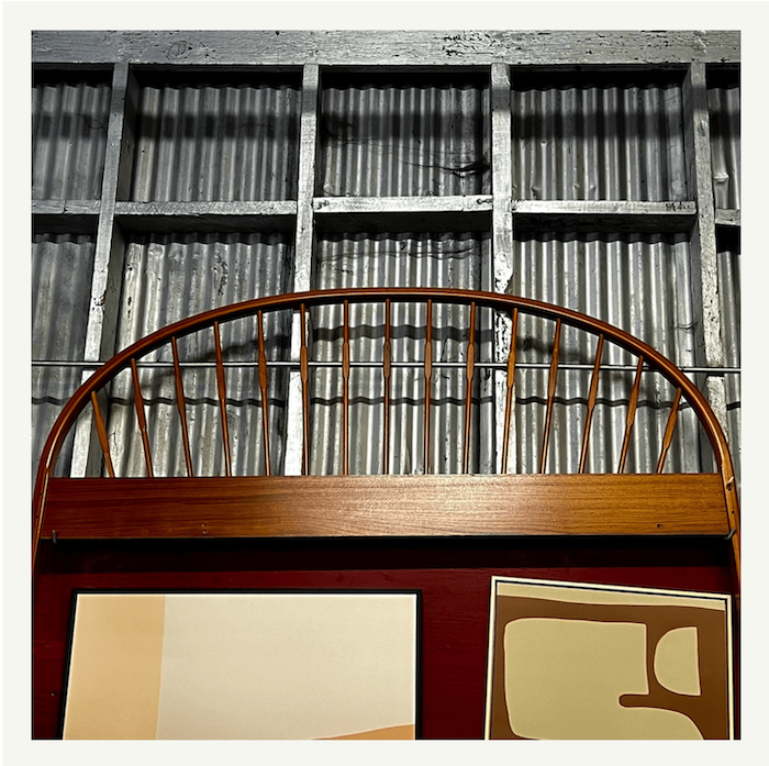 Vintage arched spindle queen headboard in honey-toned wood at Poor Honey's Oakland — begging to be lacquered by Revitaliste