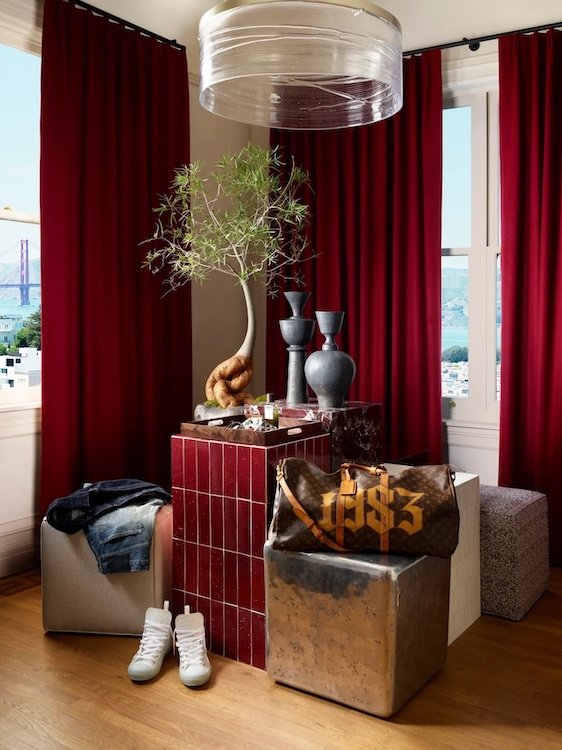 Reupholstered cube poufs by Revitaliste in the dressing room of West Red suite at the 2026 San Francisco Decorator Showcase, styled with a designer bag, bonsai tree, and views of the Golden Gate Bridge.