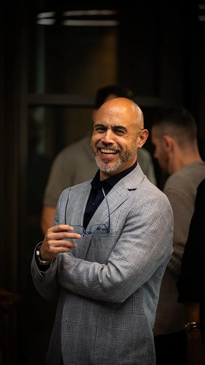 Hernando smiling in a grey suit at an event