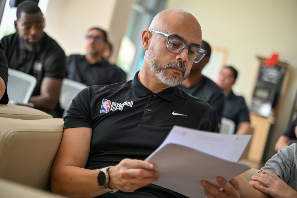 Coach H reviewing notes during a DOBA meeting