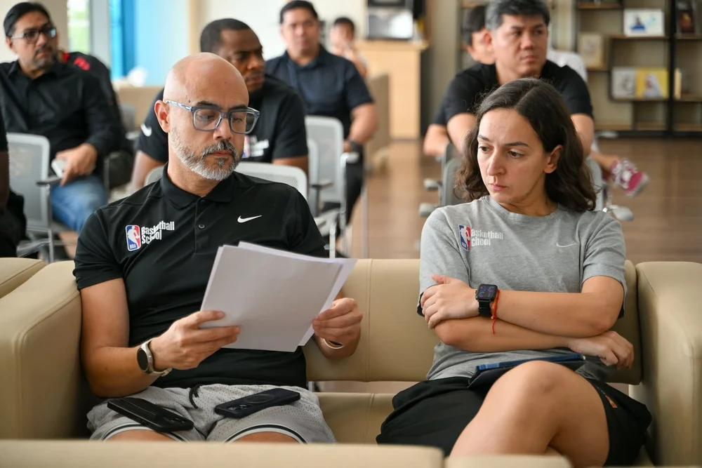 Coach H and a colleague reviewing notes during a DOBA meeting