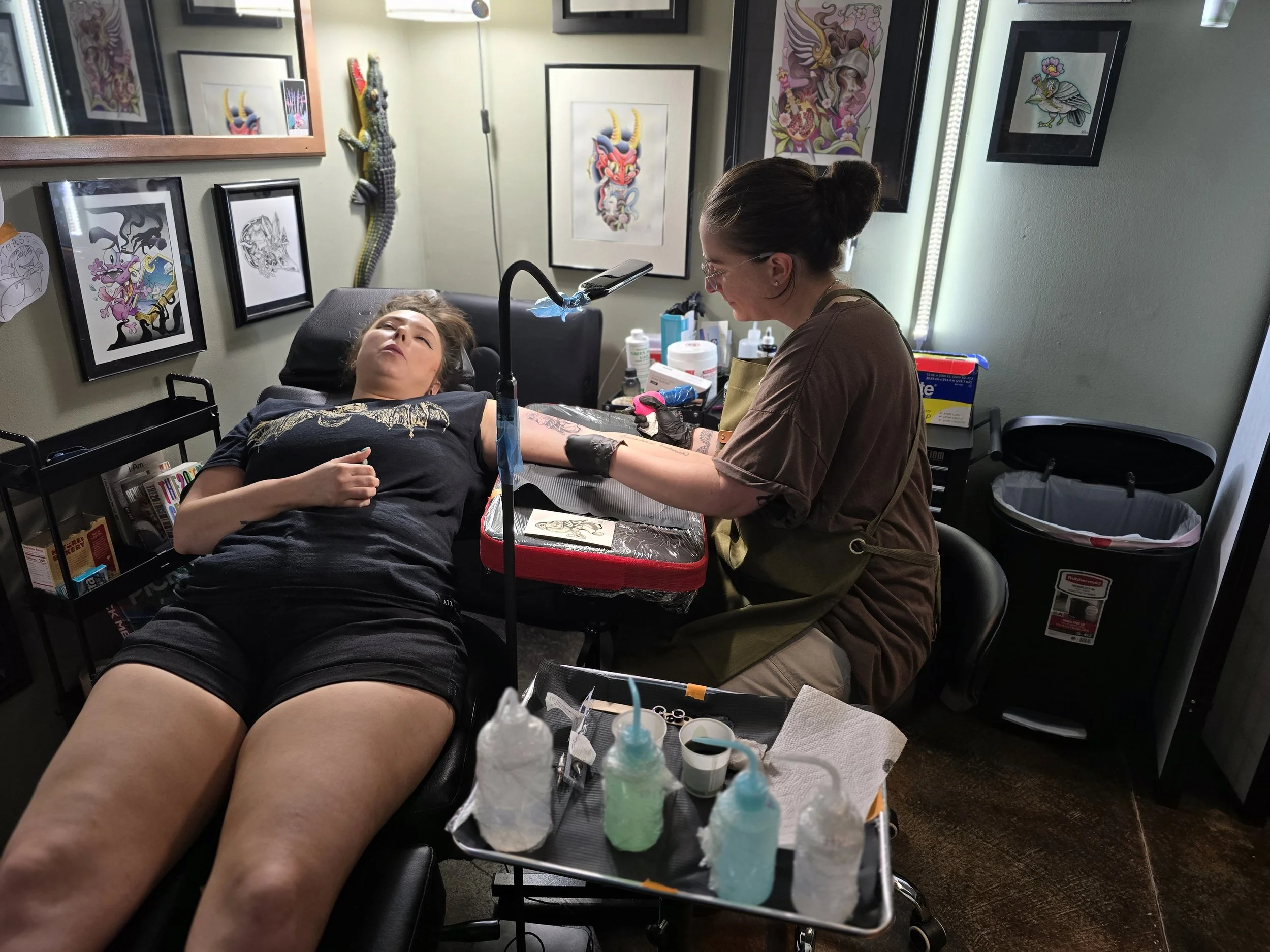 A client receives a tattoo in a calm studio setting, reflecting the mindfulness and grounding that can be part of the tattoo experience.