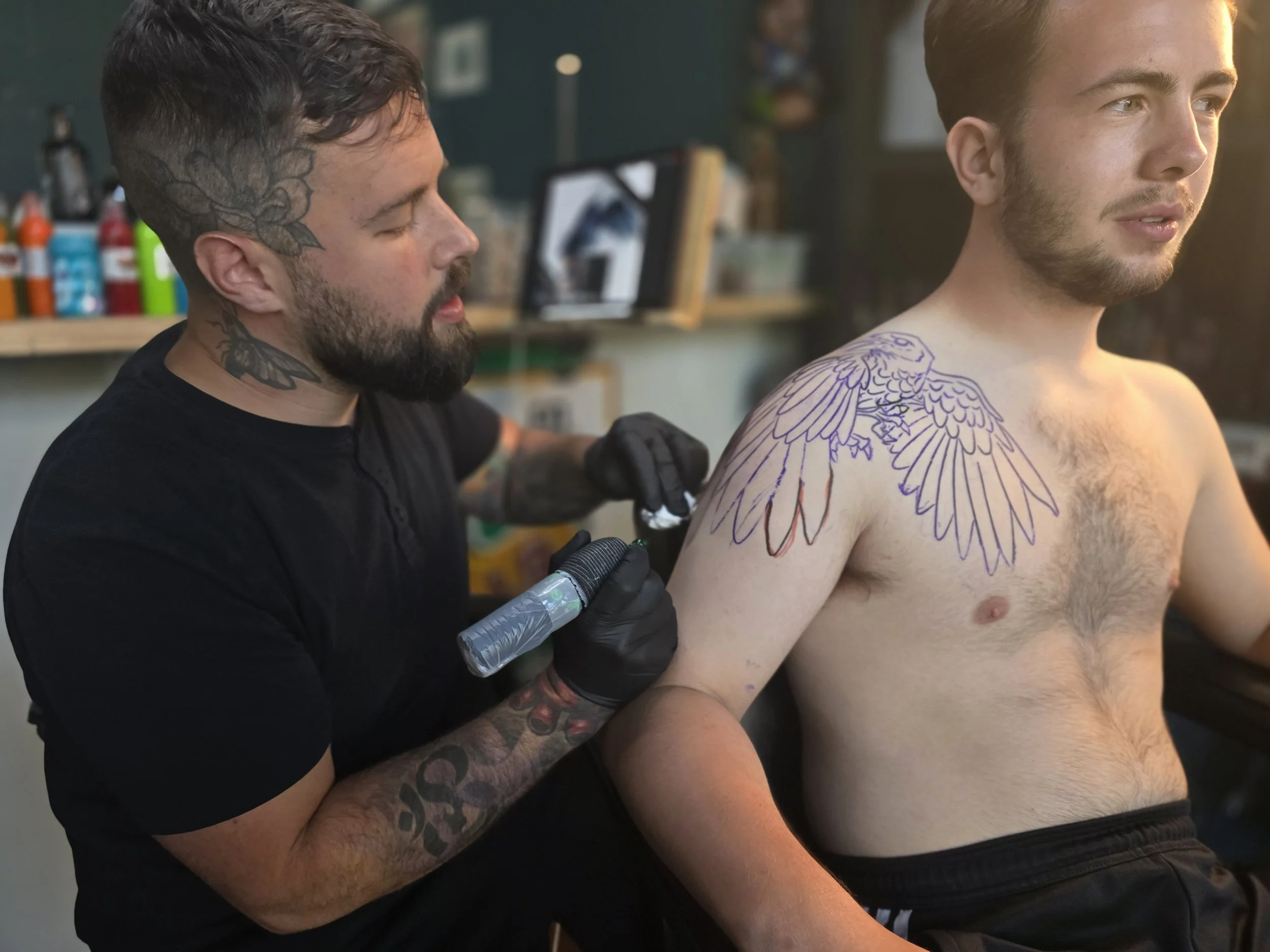 Tattoo artist working on a client at Alchemy Tattoo Collective in St. Louis.