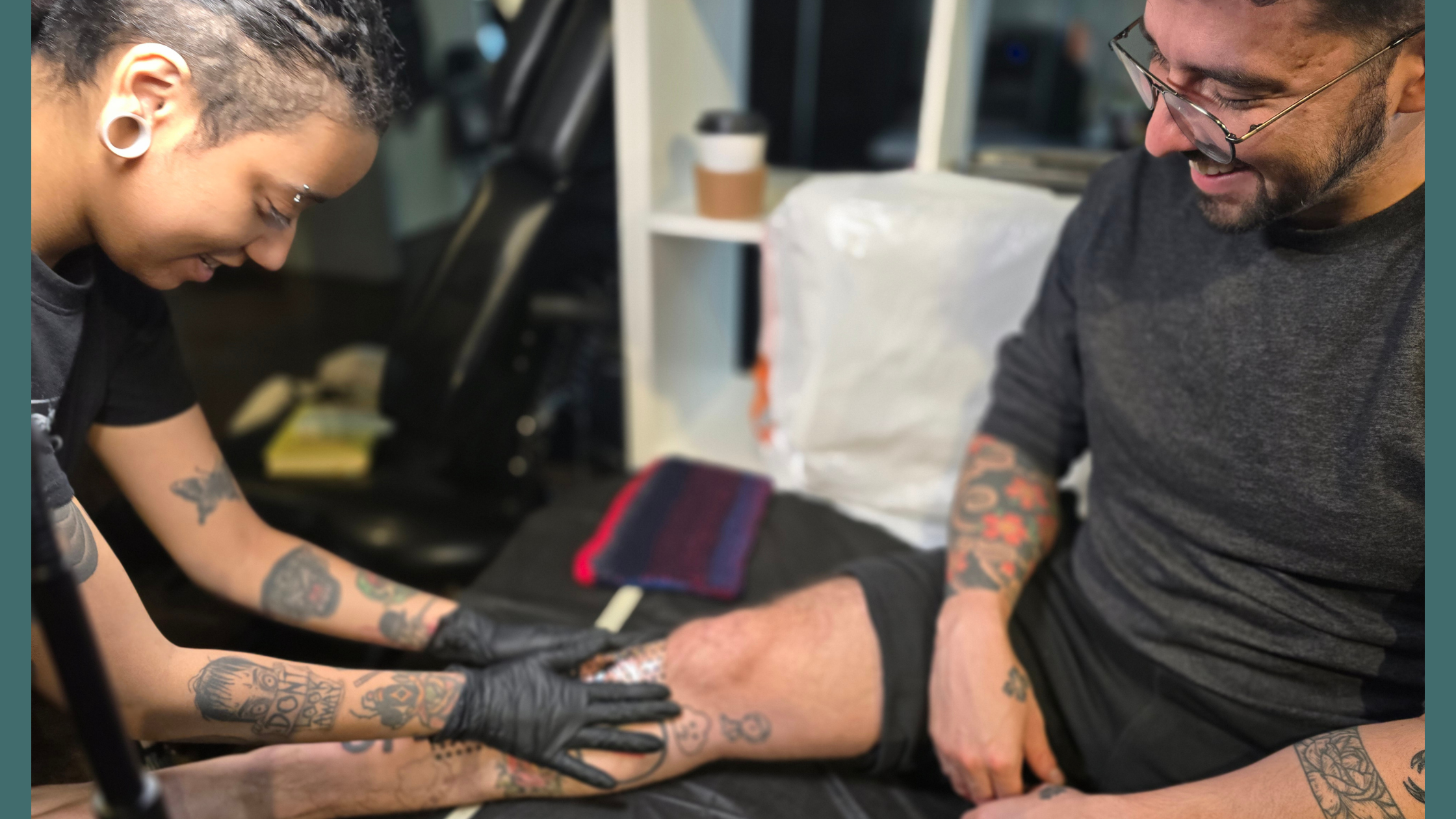 Tattoo artist working with a client at Alchemy Tattoo Collective in St. Louis.