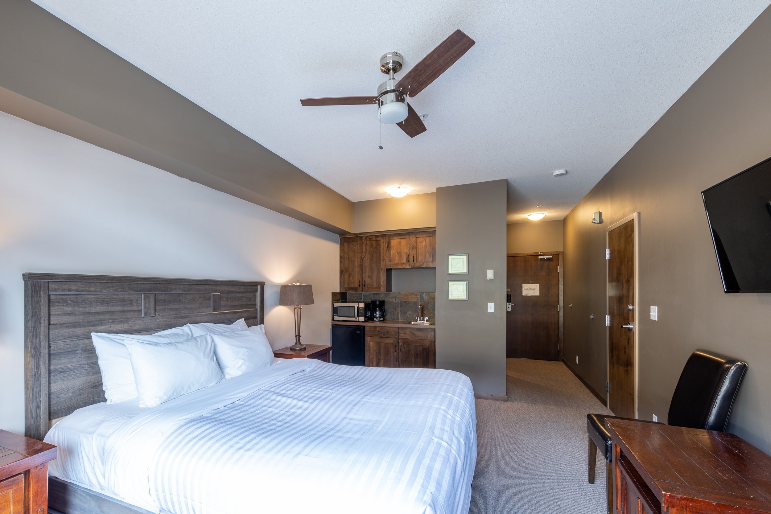 Cozy Bedroom and Convenient Kitchenette | Guest Room at Glacier Mountaineer Lodge